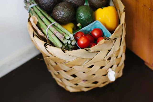 Cesto de verga com tomate, pimento, courgette e outros legumes