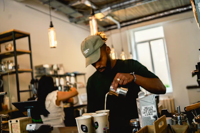 Profissional a preparar uma bebida atrás do balcão de um café